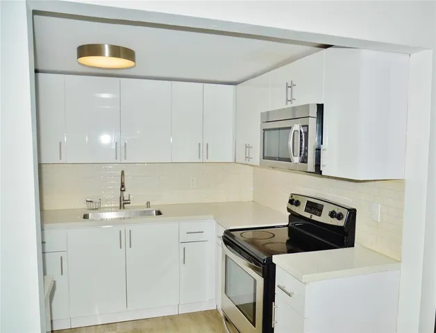 a kitchen with a sink a stove and cabinets