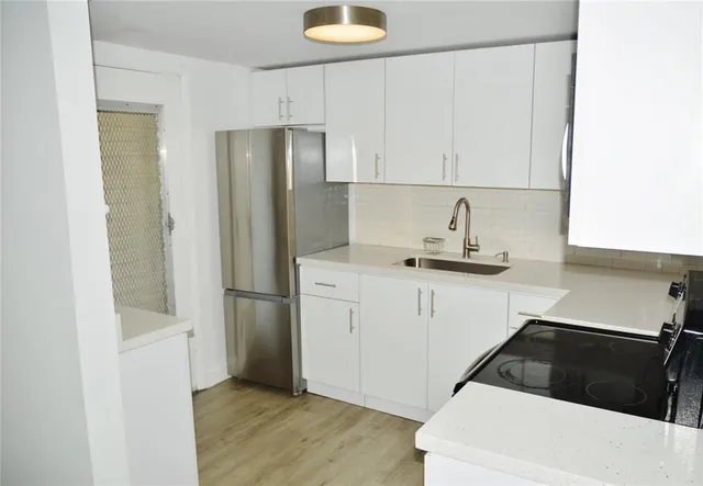 a kitchen with a refrigerator and a stove top oven