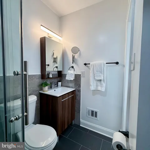 a bathroom with a sink vanity mirror and toilet