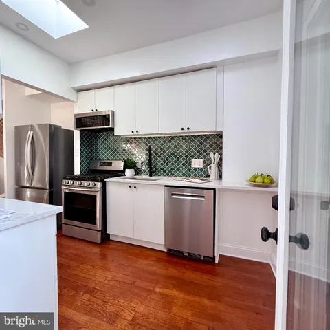 a kitchen with stainless steel appliances a refrigerator sink and stove