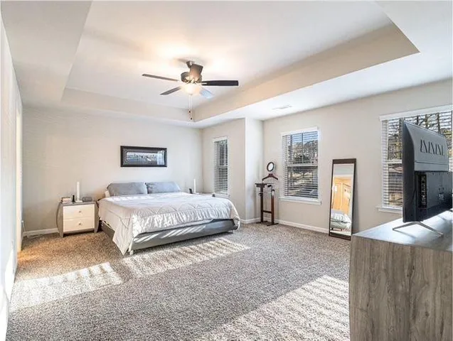 a spacious bedroom with a large bed a chandelier and closet