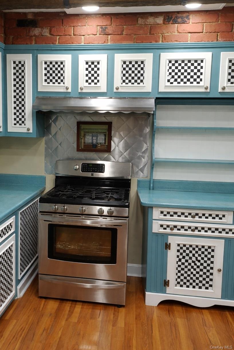 1155 Webster Avenue New Rochelle, NY 10804 - Photo 34 of 35 a kitchen with a stove a microwave cabinets and wooden floor