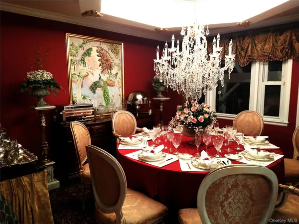 a room with furniture a chandelier and a fireplace
