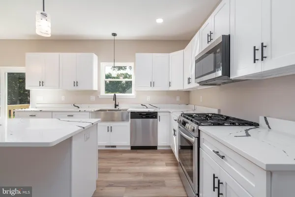 a kitchen with a sink stove top oven and cabinets