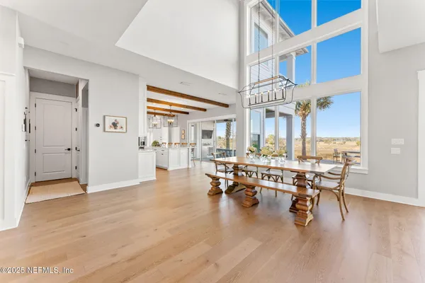 a dining hall with stainless steel appliances kitchen island granite countertop a table and chairs