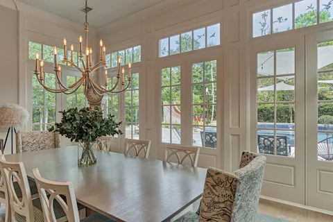 a dining room with furniture a chandelier and wooden floor