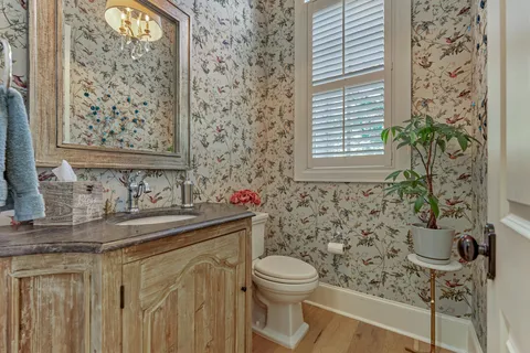 a bathroom with a granite countertop sink a toilet and a mirror
