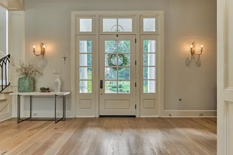 an empty room with wooden floor cabinet and windows