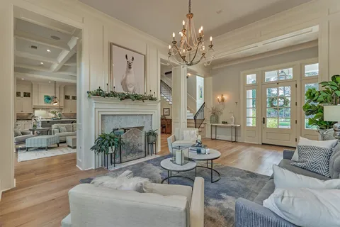 a living room with furniture a chandelier and a fireplace
