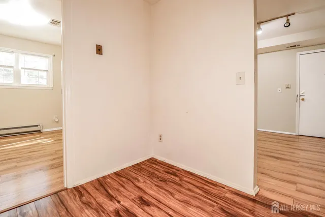 a view of empty room with wooden floor