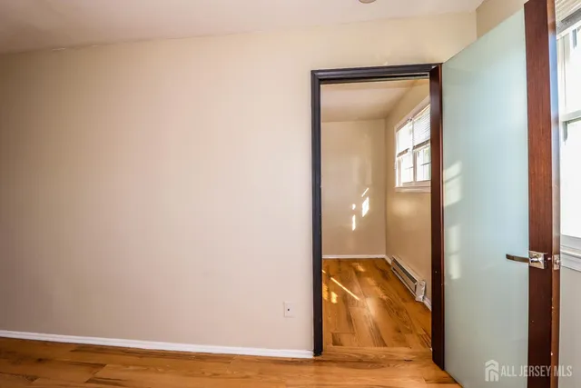 a view of a room with wooden floor and a bathroom
