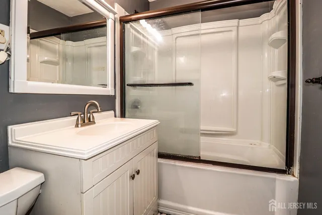 a bathroom with a sink and mirror with toilet