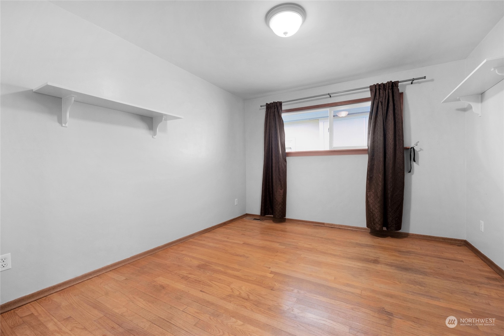 2101 Rockefeller Avenue Everett, WA 98201 - Photo 17 of 26 a view of an empty room with wooden floor and a window
