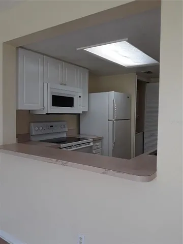 a view of a kitchen with a sink and a refrigerator