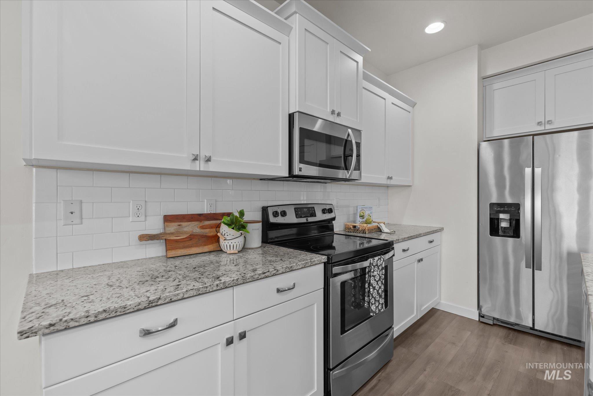 1885 North Justin Avenue Meridian, ID 83646 - Photo 13 of 27 Kitchen with stainless steel appliances, light stone counters, white cabinets, and recessed lighting