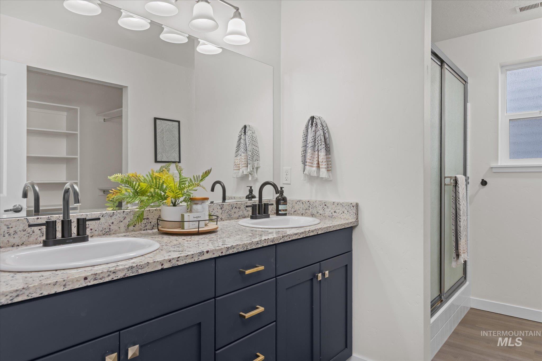 1885 North Justin Avenue Meridian, ID 83646 - Photo 19 of 27 Bathroom with a stall shower, double vanity, and light wood-style floors