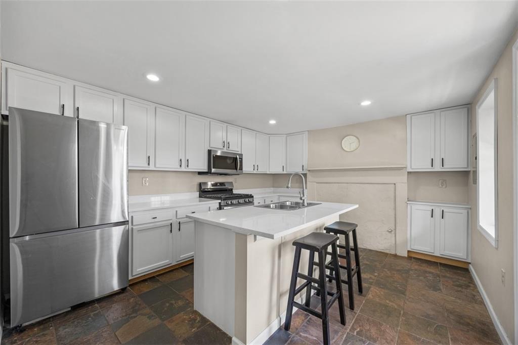 1312 Boyle Street Pittsburgh, PA 15212 - Photo 4 of 50 a kitchen with stainless steel appliances a refrigerator stove microwave and cabinets
