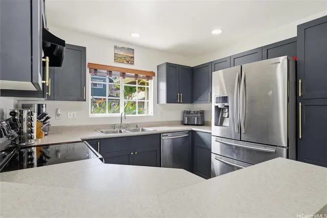 a kitchen with granite countertop a refrigerator sink and microwave