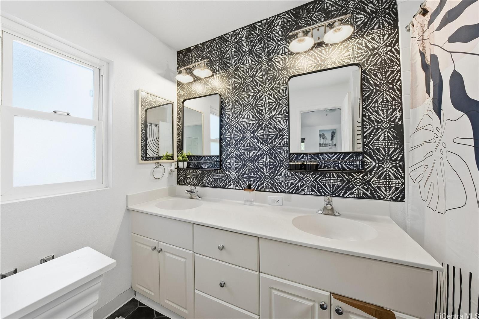 87-1958 Pakeke Street, Unit T Waianae, HI 96792 - Photo 18 of 25 a bathroom with a toilet sink and mirror