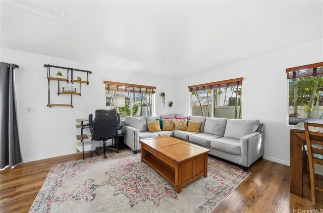 a living room with furniture wooden floor and a window