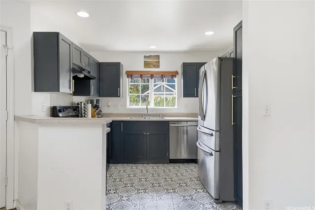 a kitchen with a refrigerator and a stove top oven