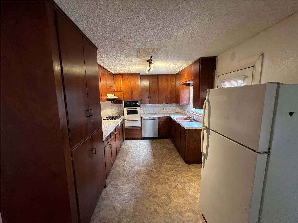 1200 Bentwood Road Austin, TX 78722 - Photo 5 of 16 a kitchen with a refrigerator a sink and dishwasher