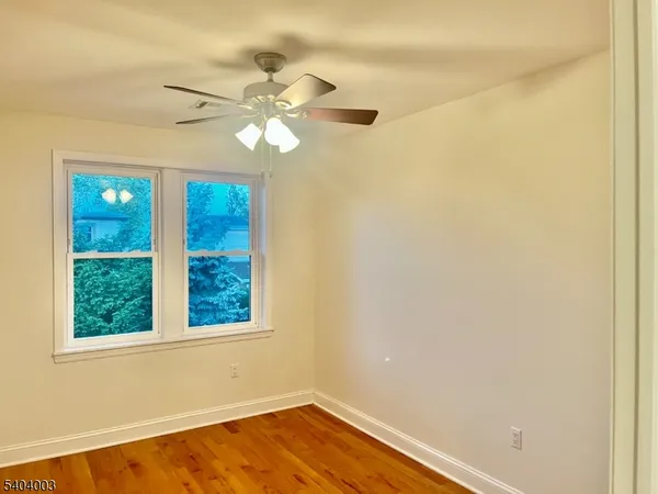 an empty room with a window and a fan