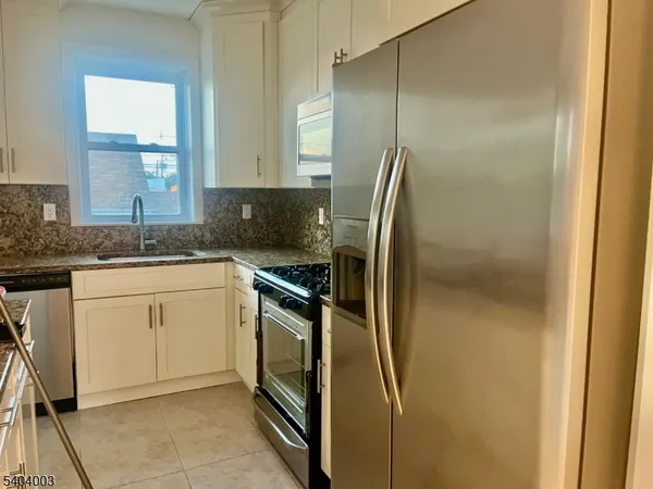 a kitchen with a refrigerator sink and cabinets