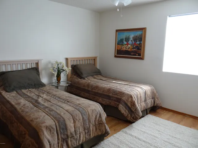 a bedroom with two beds and painting on the wall