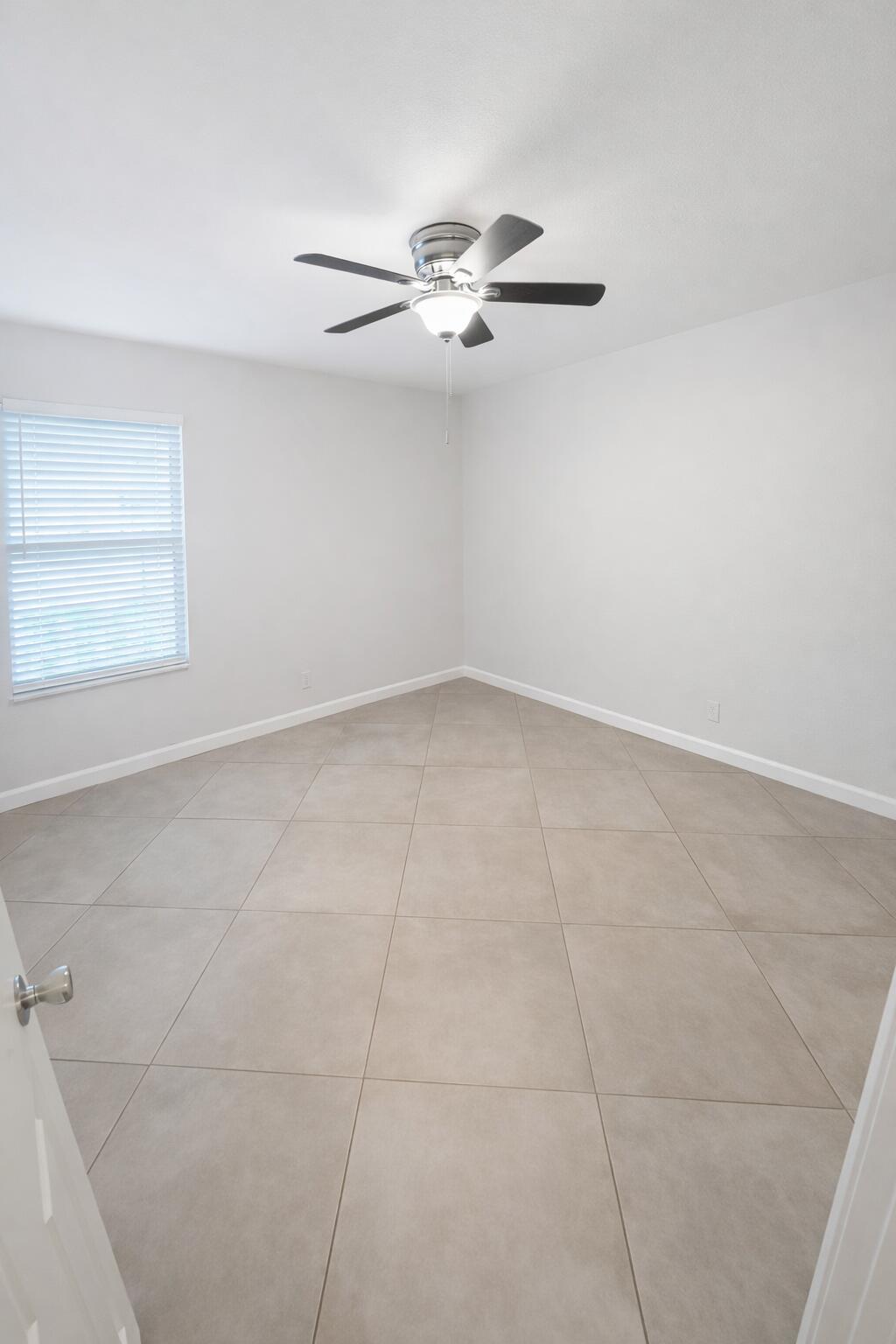 3355 Jaywood Terrace, Unit J113 Boca Raton, FL 33431 - Photo 16 of 34 an empty room with windows and fan