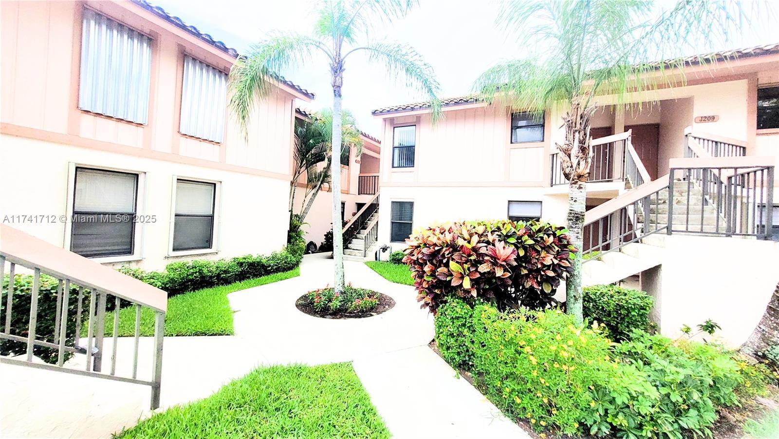 3355 Jaywood Terrace, Unit J113 Boca Raton, FL 33431 - Photo 26 of 34 a view of a house with a garden and pathway