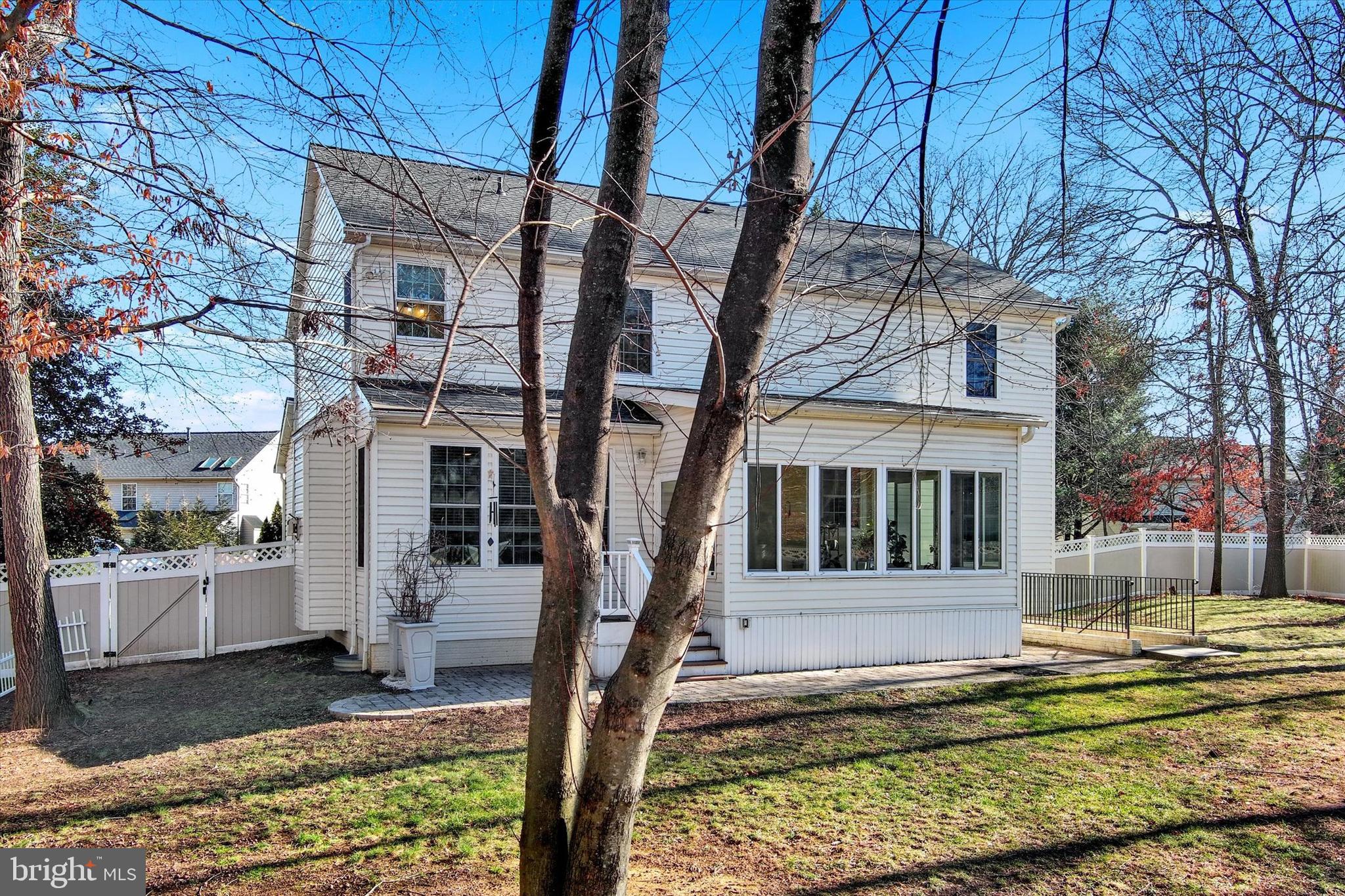1590 Chapman Road Crofton, MD 21054 - Photo 42 of 70 a view of a white house next to a yard with a tree and wooden fence