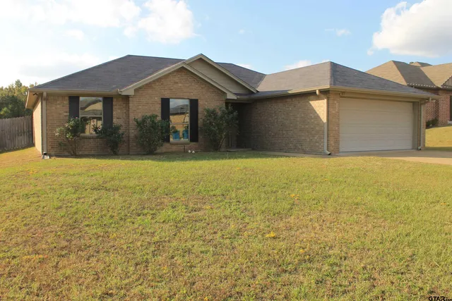 a front view of the house with a garden
