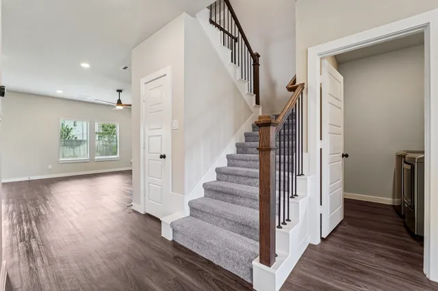 a view of a hallway with wooden floor and staircase