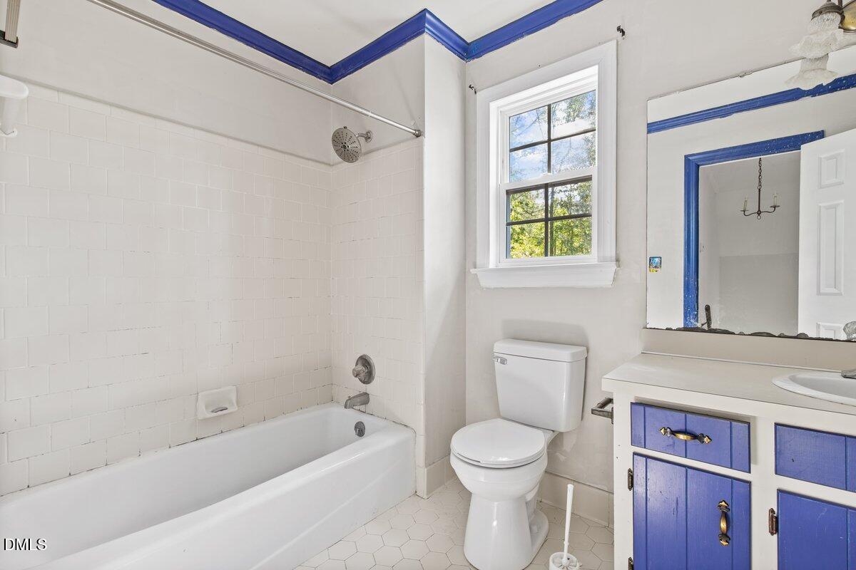3812 Providence Road Rocky Mount, NC 27803 - Photo 14 of 18 a bathroom with a bathtub sink vanity mirror and toilet