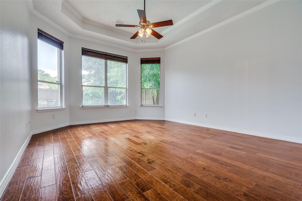 3421 Neiman Road Plano, TX 75025 - Photo 17 of 40 Unfurnished room with a raised ceiling, wood-type flooring, crown molding, and a ceiling fan