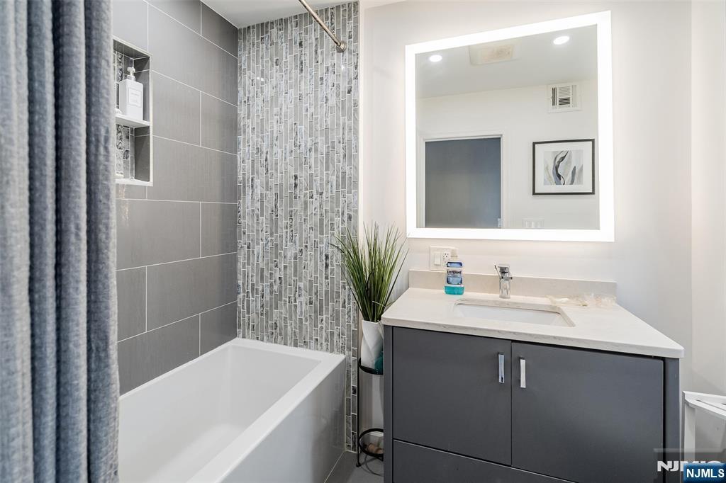 75 Pine Street Hackensack, NJ 07601 - Photo 12 of 23 a bathroom with a sink and a bathtub