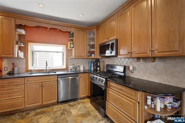 a kitchen with stainless steel appliances granite countertop a sink stove and microwave