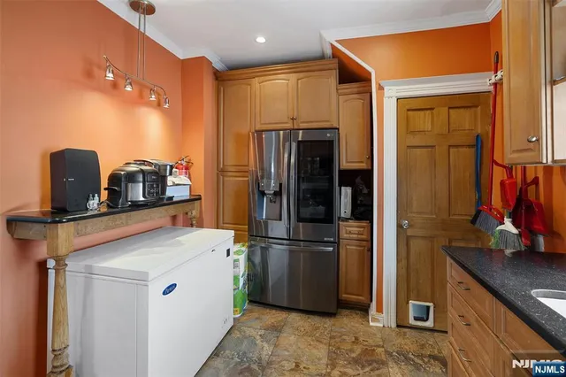 a kitchen with stainless steel appliances granite countertop a refrigerator and a sink