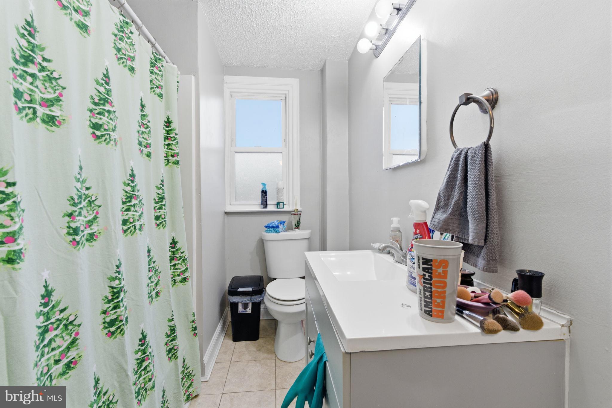 4524 Robbins Street Philadelphia, PA 19135 - Photo 12 of 26 a bathroom with a sink a toilet and shower curtain