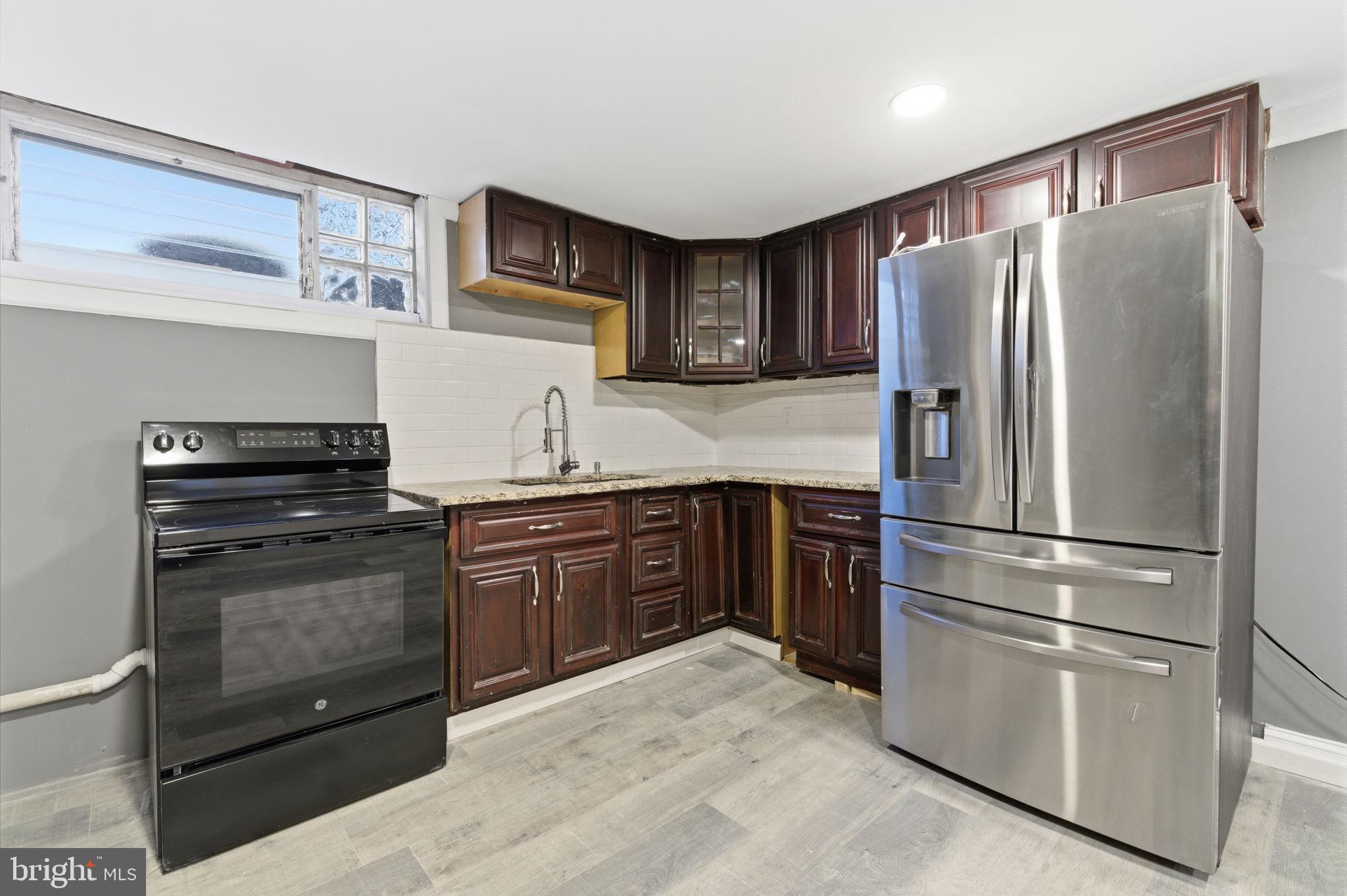4524 Robbins Street Philadelphia, PA 19135 - Photo 19 of 26 a kitchen with granite countertop stainless steel appliances and wooden cabinets