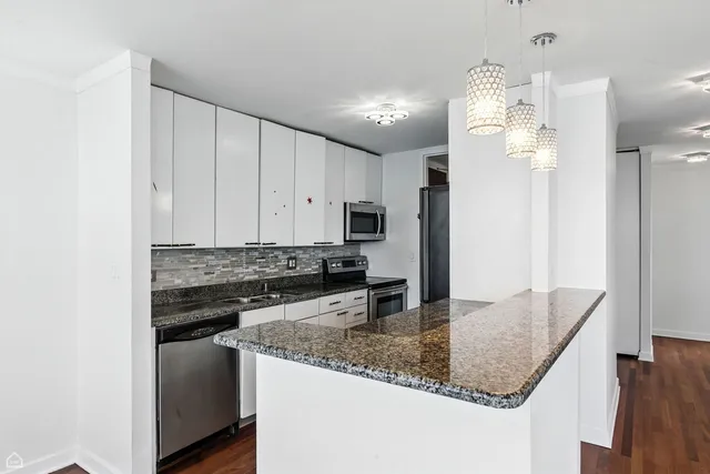 a kitchen with stainless steel appliances granite countertop a sink refrigerator and microwave