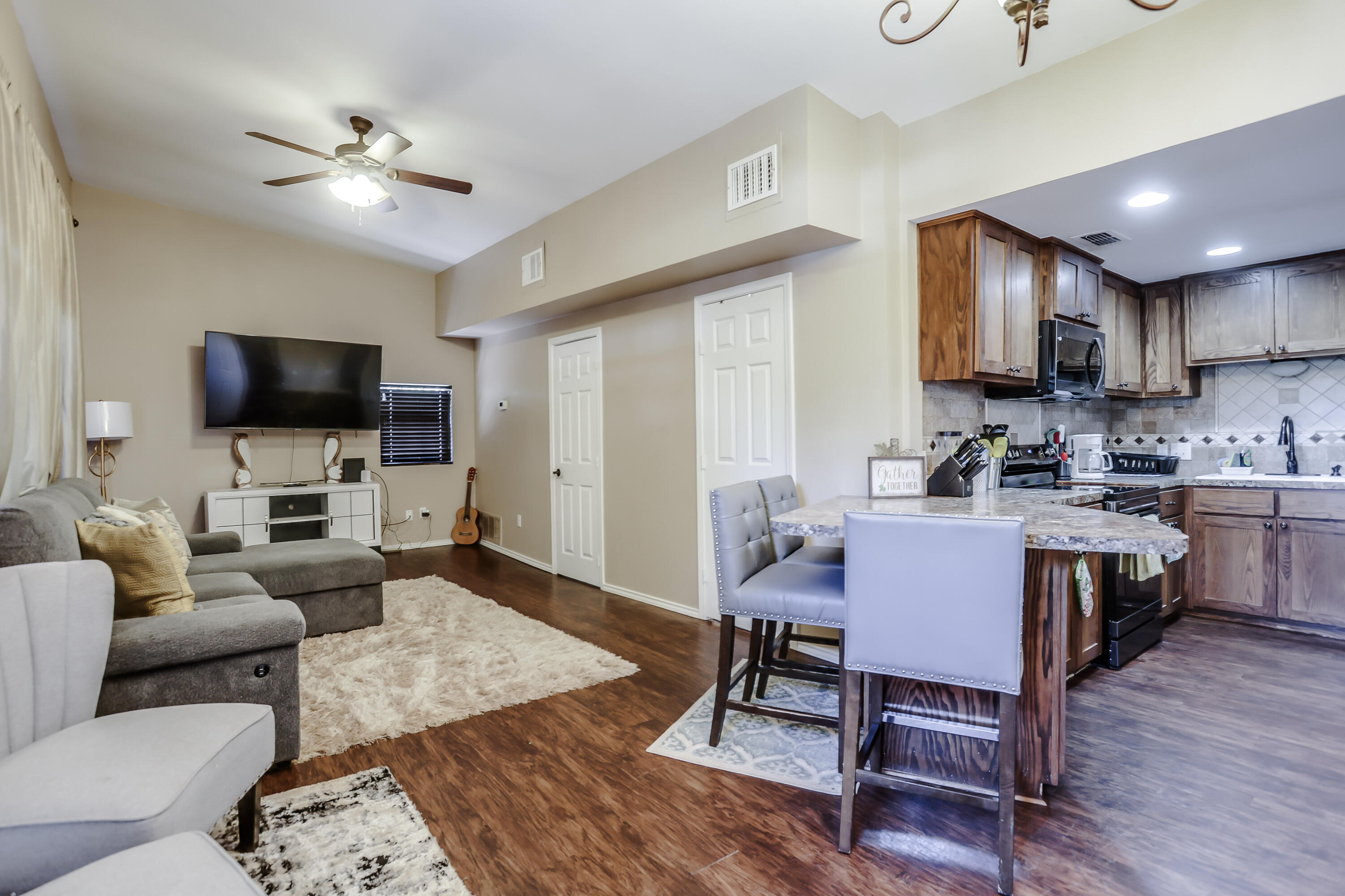 68 Pony Express Trail Lubbock, TX 79404 - Photo 8 of 15 a living room with furniture a flat screen tv and kitchen view