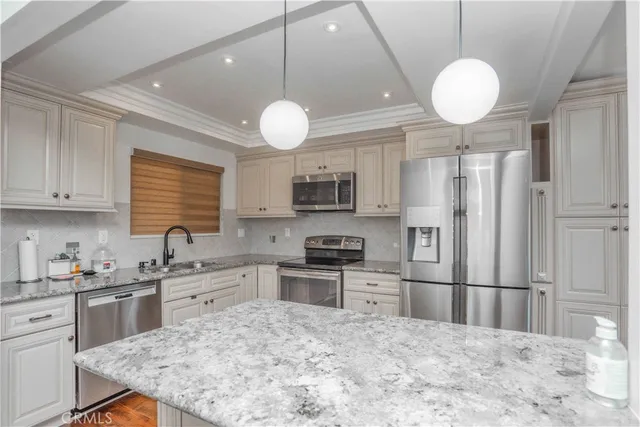 a kitchen with stainless steel appliances granite countertop a sink refrigerator stove and microwave