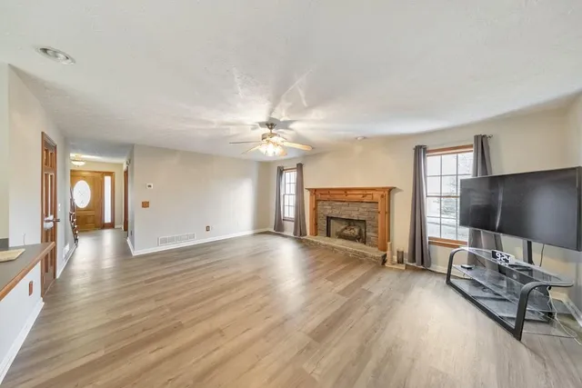a view of a livingroom with wooden floor and a fireplace