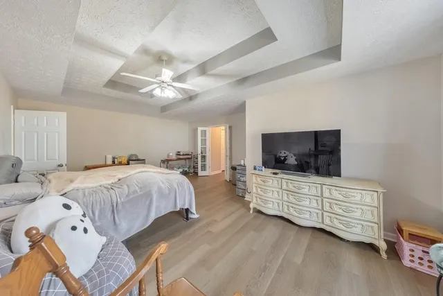 a spacious bedroom with a bed and a television