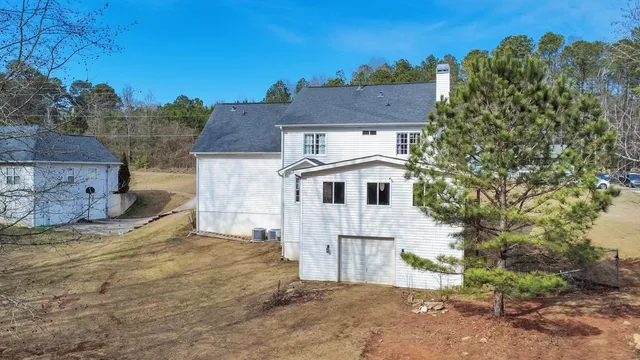 a front view of a house with yard garage and trees