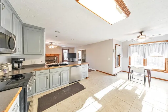 a kitchen with stainless steel appliances kitchen island granite countertop a sink and cabinets