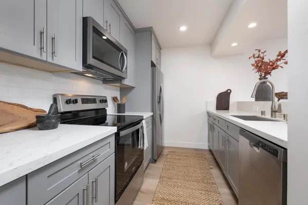 a kitchen with a sink and steel appliances