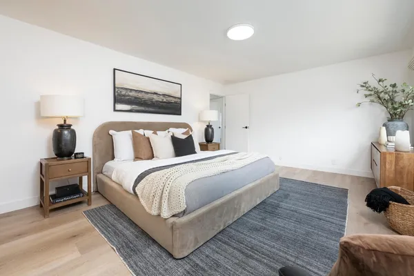 a bedroom with bed and wooden floor